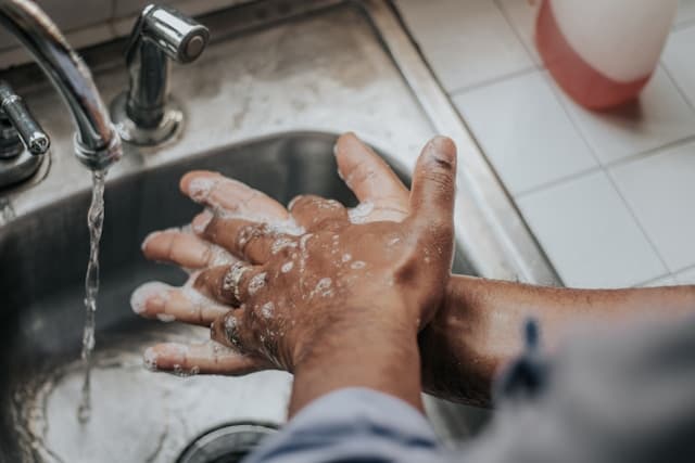 Manos lavándose repetidamente en un lavabo